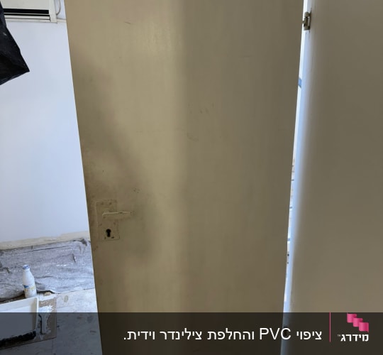 דלת לבנה עם ידית ומנעול, צבע ומברשת על הרצפה
